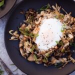 Cabbage hash on plate with egg on top next to fork.