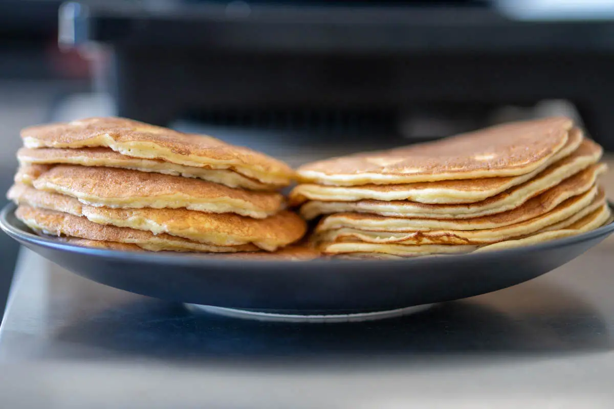 Two stacks of almond flour pancakes, the one on the left with beaten egg whites, the one on the right-hand side without.