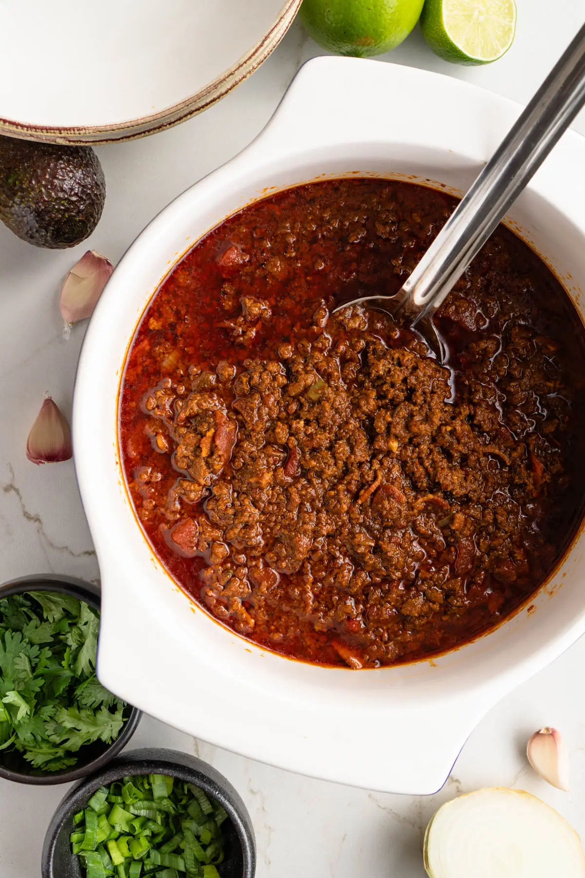 Full pot of chili with serving spoon.