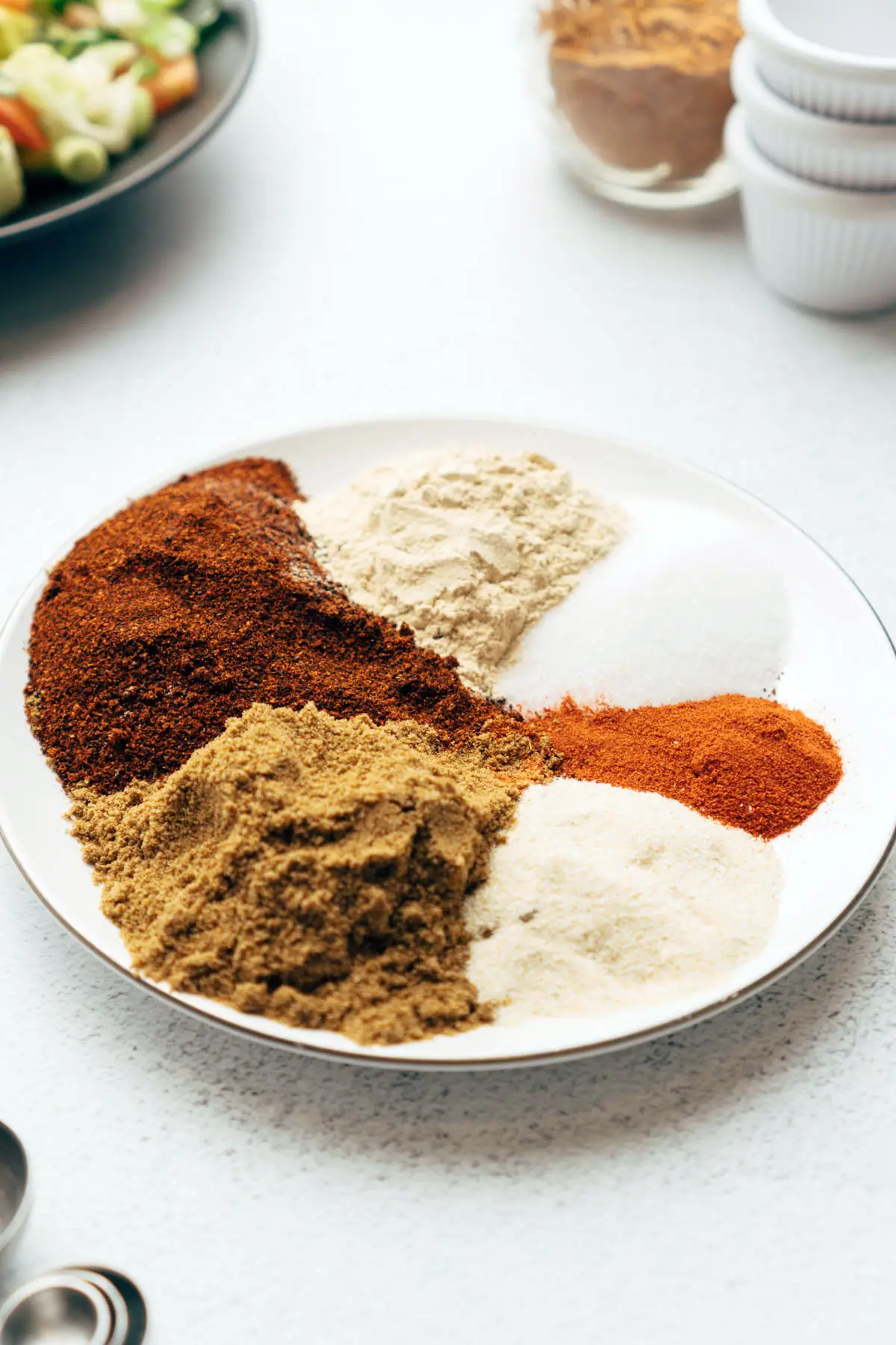 Spices for taco seasoning on plate.