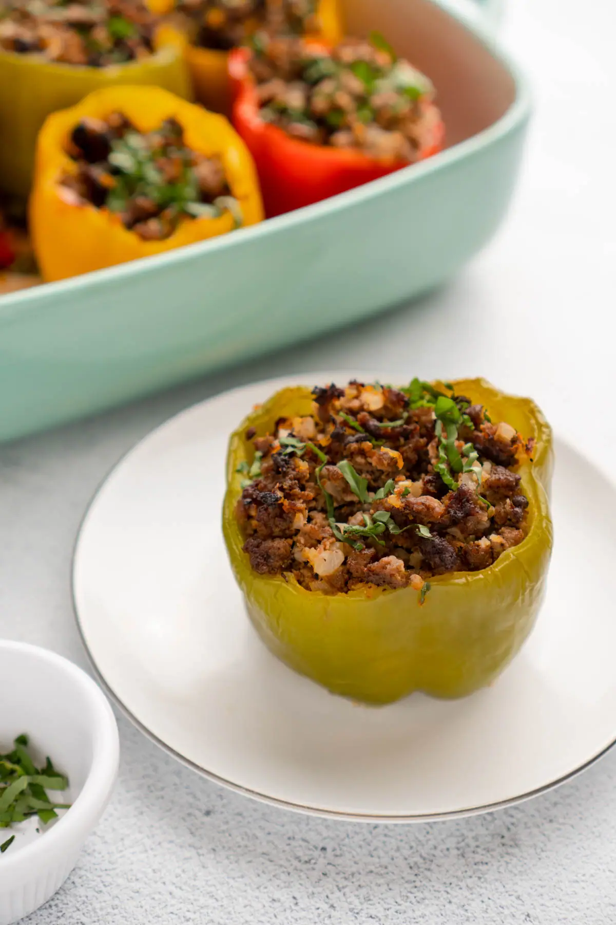 A stuffed green bell pepper on a plate, ready to serve.